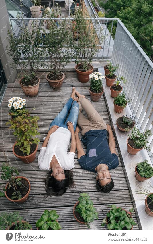 Entspanntes Paar auf dem Balkon liegend Balkone entspannt entspanntheit relaxt liegt Pärchen Paare Partnerschaft Entspannung relaxen entspannen Mensch Menschen