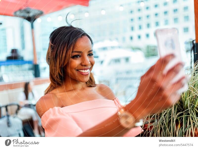 Lächelnde Frau macht ein Selfie in der Stadt weiblich Frauen lächeln Selfies Handy Mobiltelefon Handies Handys Mobiltelefone Erwachsener erwachsen Mensch