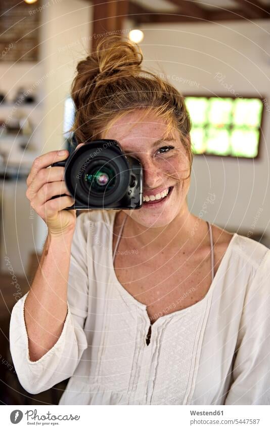 Porträt einer lachenden jungen Frau, die mit der Kamera fotografiert weiblich Frauen Portrait Porträts Portraits Kameras fotografieren Erwachsener erwachsen