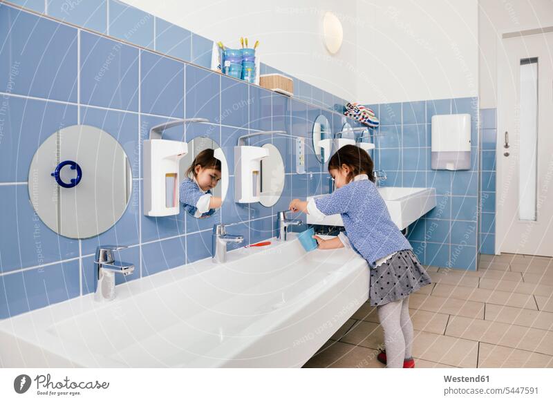 Kleines Mädchen benutzt Wasser zum Zähneputzen im Badezimmer eines Kindergartens weiblich Kindergaerten Kindergärten Kids Mensch Menschen Leute People Personen