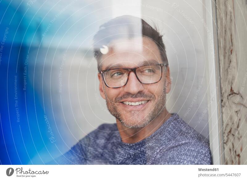 Porträt eines lächelnden Mannes hinter Glasscheibe mit Brille entspannt entspanntheit relaxt Brillen Portrait Porträts Portraits Glasscheiben Männer männlich