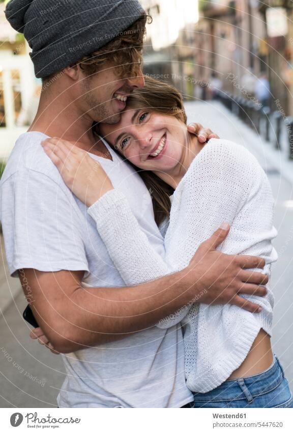 Glückliches junges Paar umarmt sich in der Stadt Pärchen Paare Partnerschaft glücklich glücklich sein glücklichsein Liebe lieben lächeln umarmen Umarmung