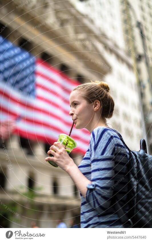 USA, New York City, Frau trinkt einen Smoothie vor der New Yorker Börse Smoothies trinken weiblich Frauen Getränk Getraenk Getränke Getraenke Food and Drink