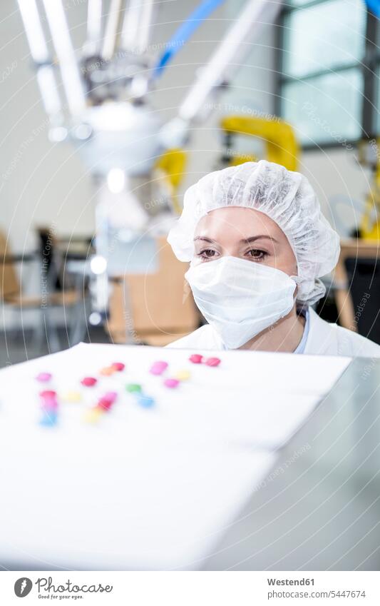 Frau beobachtet Roboter bei der Handhabung von Süßigkeiten Süßes Fabrik Fabriken weiblich Frauen Essen Food Food and Drink Lebensmittel Essen und Trinken
