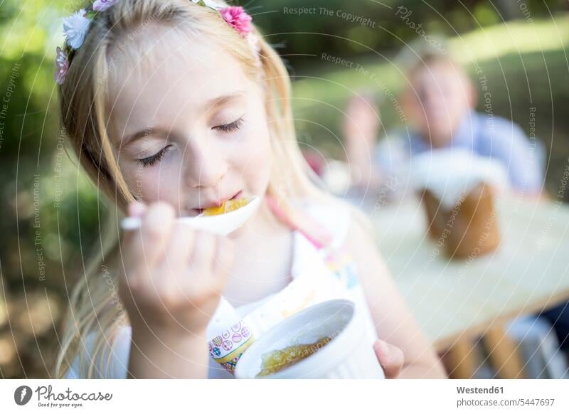 Mädchen isst Gelee im Freien weiblich essen essend Kind Kinder Kids Mensch Menschen Leute People Personen Götterspeise Goetterspeise Wackelpudding Wackelpeter