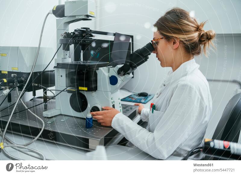 Labortechniker mit Mikroskop im Labor untersuchen prüfen Laborantin Laborantinnen Labore Frau weiblich Frauen Mikroskope arbeiten Arbeit Untersuchung mustern