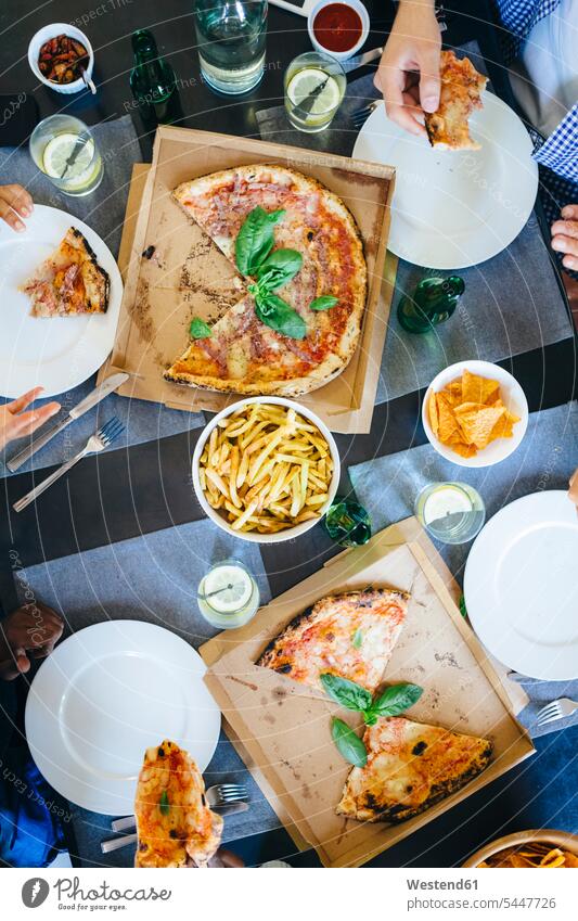 Freunde bei Pizza und Pommes Frites Hand Hände Tisch Tische essen essend Pizzen Mensch Menschen Leute People Personen Freundschaft Kameradschaft Essen Food