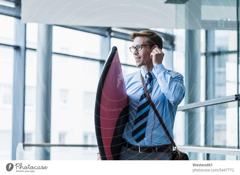 Geschäftsmann mit Kopfhörern mit Surfbrett im Büro Businessmann Businessmänner Geschäftsmänner Surfbretter surfboard surfboards Geschäftsleute Geschäftspersonen