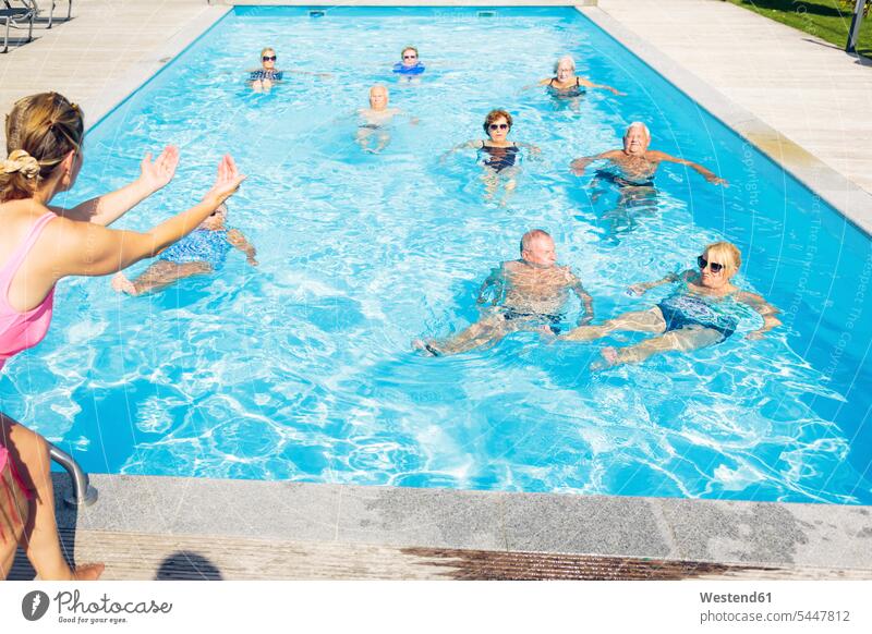 Gruppe von Senioren mit einem Trainer, der Wassergymnastik im Schwimmbad macht Aqua Aerobic alte ältere Swimmingpool Swimmingpools Schwimmbecken Swimming Pool