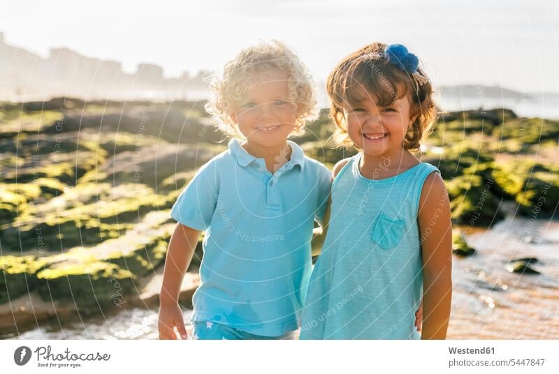 Porträt eines glücklichen kleinen Jungen und Mädchens Seite an Seite am Strand Freunde Beach Straende Strände Beaches Portrait Porträts Portraits Freundschaft