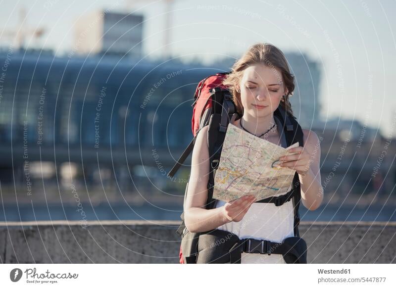 Deutschland, Berlin, Junge Frau mit Rucksack schaut auf die Karte besichtigen Besichtigung Teenagerin junges Mädchen Teenagerinnen weiblich junge Frau Stadtplan