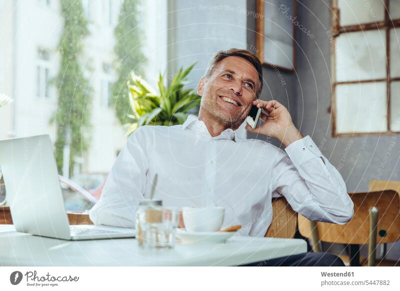Lächelnder Geschäftsmann am Telefon im Cafe Handy Mobiltelefon Handies Handys Mobiltelefone Portrait Porträts Portraits Kaffeehaus Bistro Cafes Café Cafés