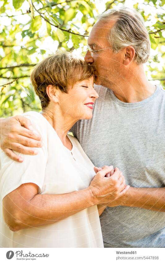 Glückliches älteres Paar umarmt und küsst sich im Freien lächeln umarmen Umarmung Umarmungen Arm umlegen Pärchen Paare Partnerschaft Mensch Menschen Leute