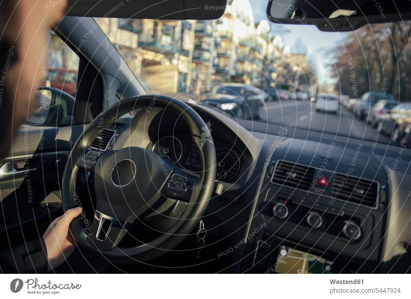 Lenkrad und Hand eines Mannes, der ein Auto durch die Stadt fährt lenken Autofahrer autofahren Sonnenlicht Wagen PKWs Automobil Autos Fahrer Mensch Menschen
