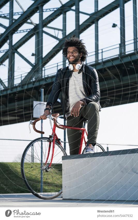Mann auf Fahrrad vor der Brücke Männer männlich lächeln Bikes Fahrräder Räder Rad Erwachsener erwachsen Mensch Menschen Leute People Personen Raeder Seitenblick