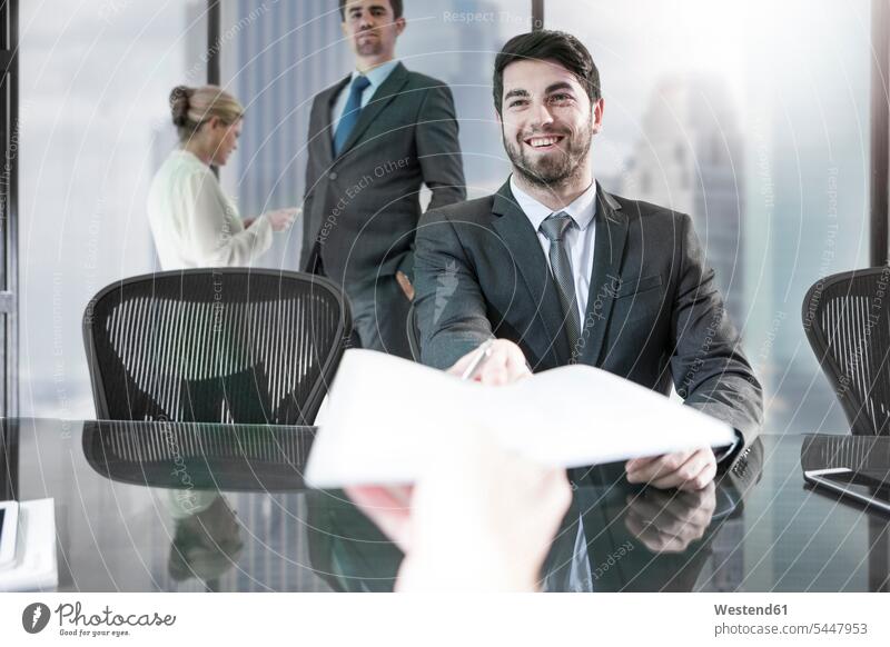 Geschäftsmann erhält Papier im Stadtbüro geben überreichen lächeln Büro Office Büros Businessmann Businessmänner Geschäftsmänner Kollegen Arbeitskollegen