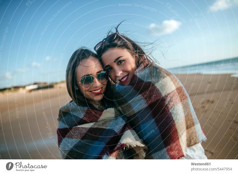 Porträt von zwei mit einer Decke bedeckten Frauen am Strand Freundinnen Portrait Porträts Portraits Beach Straende Strände Beaches Freunde Freundschaft