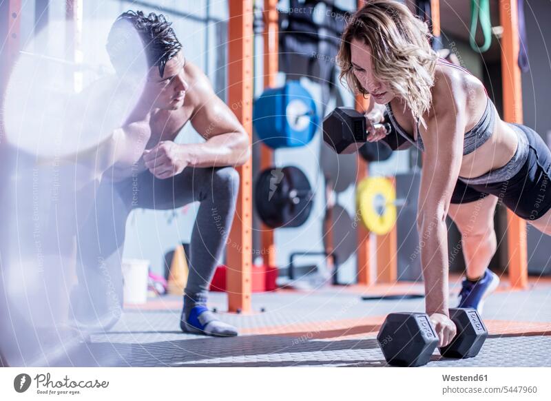 Fitnesstrainerin mit einer Frau, die im Fitnessstudio Hantelstößen macht trainieren Fitnessclubs Fitnessstudios Turnhalle Hanteln fit Gesundheit gesund Sport
