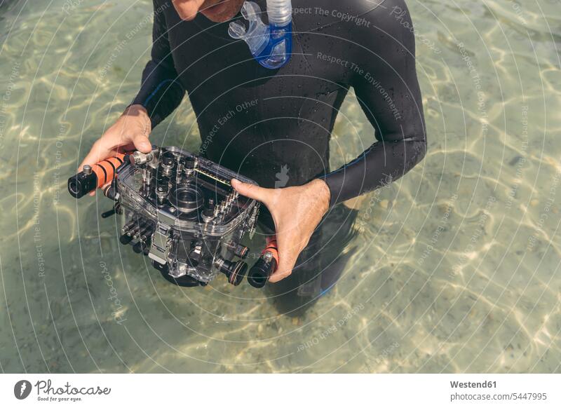 Mann hält Unterwasser-DSLR-Kamerakoffer in einem See Taucher Kameras Männer männlich Fotoapparat Fotokamera tauchen Wassersport Sport Erwachsener erwachsen