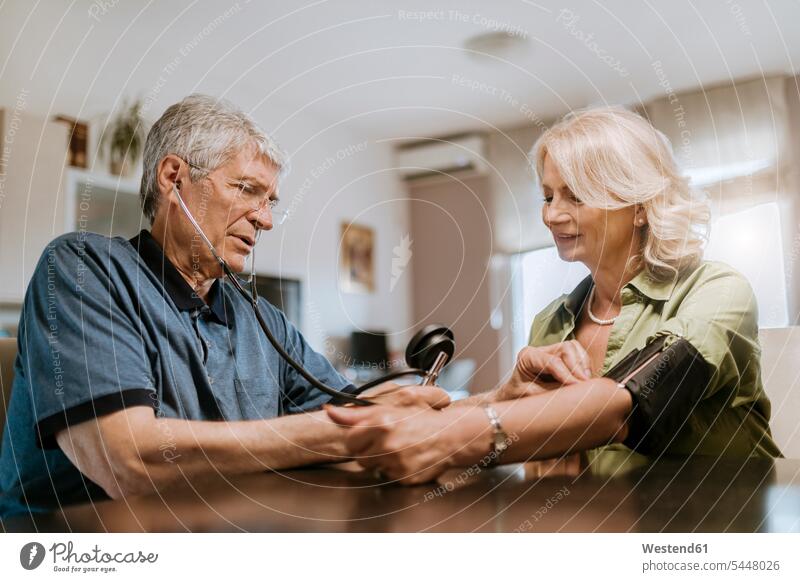 Älteres Ehepaar bei der Blutdruckmessung Paar Pärchen Paare Partnerschaft Senior ältere Männer älterer Mann Senioren Krankheit Erkrankungen Krankheiten Medizin