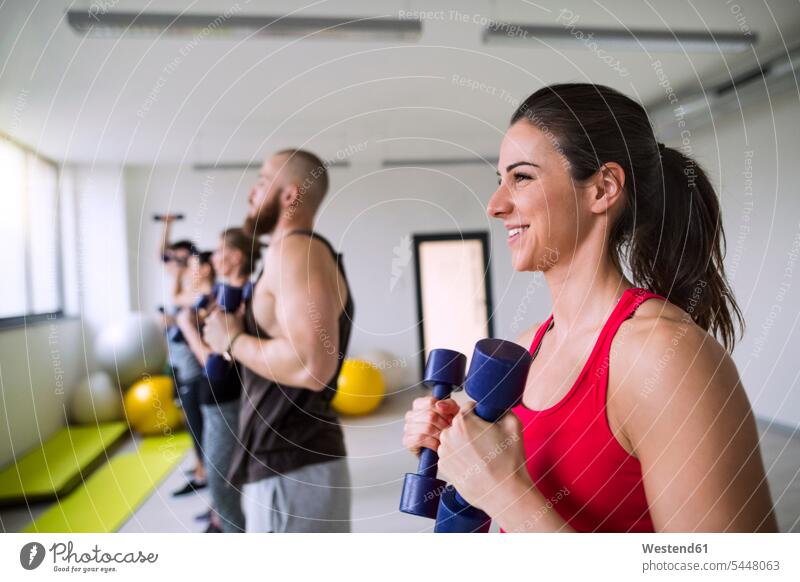 Gruppe von Sportlern, die mit Hanteln im Fitnessstudio trainieren Fitnessclubs Fitnessstudios Turnhalle lächeln fit Gesundheit gesund Trainieren Übung Üben