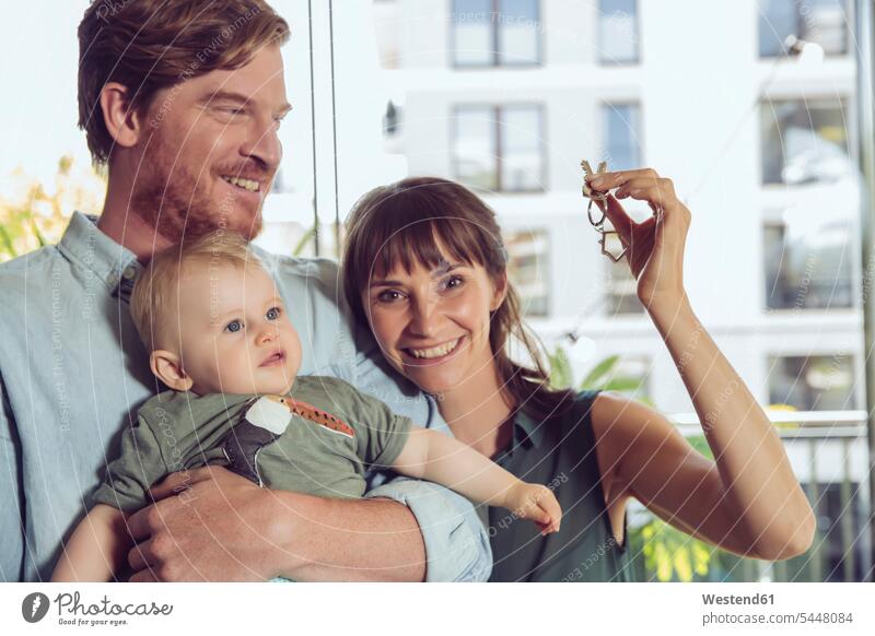 Glückliches Paar mit Babyschlüssel Wohnung Mietwohnungen wohnen Schlüssel lächeln Pärchen Paare Partnerschaft Babies Säuglinge Kind Kinder glücklich