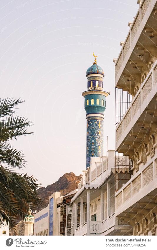 Sicht auf Minarett mit Ornamenten und Berge im Hintergrund Oman Muskat Stadt Arabische Halbinsel Häuser orientalisch Architektur Baustil Gebäude Tourismus