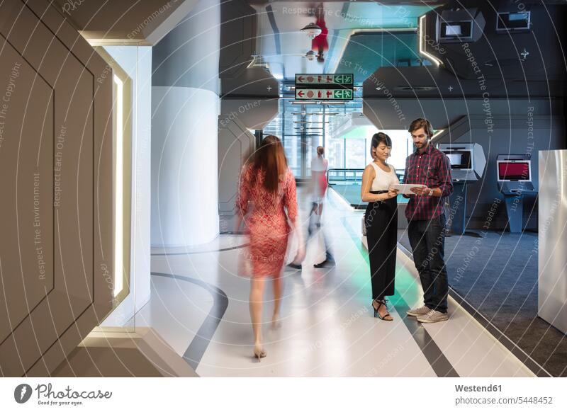 Geschäftsleute diskutieren auf einem belebten Bürokorridor futuristisch Zukunft Future Visionär Office Büros Teilen Sharing Korridor Flur Gang Fure Korridore