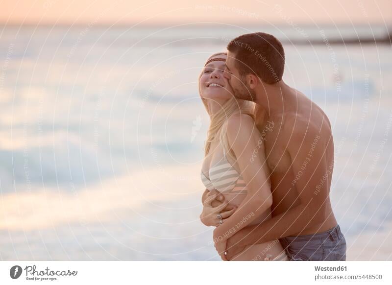 Romantisches Paar küsst sich am Strand Urlaub Ferien küssen Küsse Kuss Erotik Sexualität glücklich Glück glücklich sein glücklichsein romantisch schwärmerisch