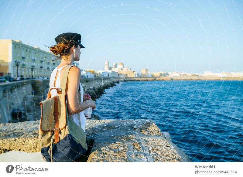 Spanien, Andalusien, Cádiz, junge Frau schaut auf das Meer stehen stehend steht Meere weiblich Frauen Gewässer Wasser Erwachsener erwachsen Mensch Menschen