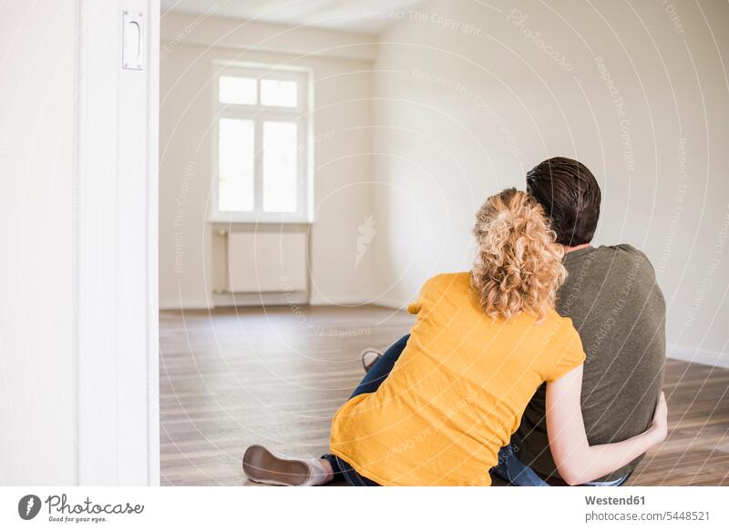 Junges Paar in neuer Wohnung auf dem Boden sitzend wohnen Wohnungen sitzt Pärchen Paare Partnerschaft Wohnen Mensch Menschen Leute People Personen schauen