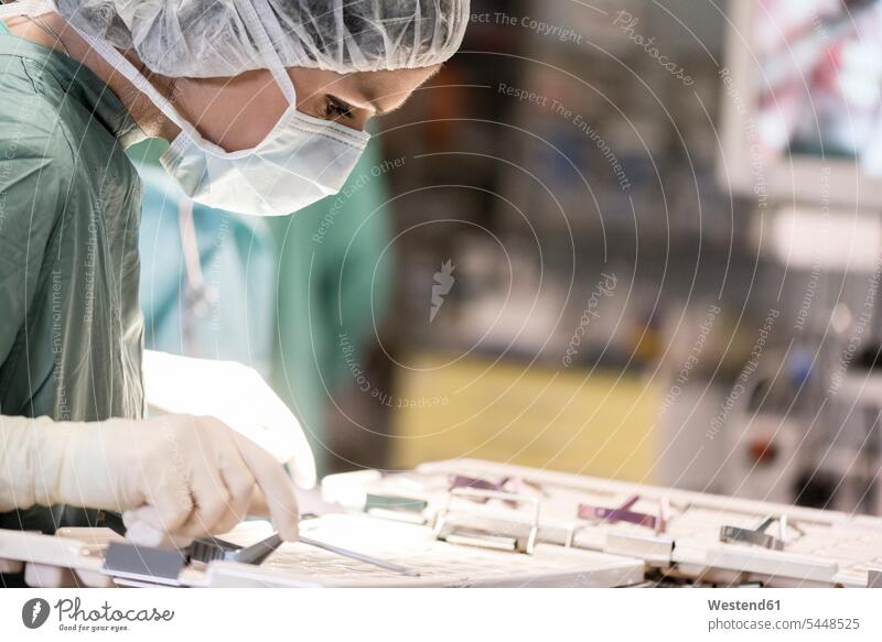 OP-Schwester auf der Suche nach einem Instrument Operationsschwester Instrumentenschwestern OP-Schwestern Operationsschwestern Operationen operieren Chirurgie