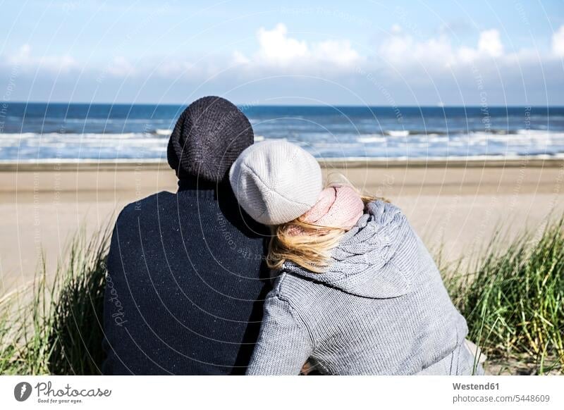 In den Dünen sitzendes Ehepaar Strand Beach Straende Strände Beaches entspannt entspanntheit relaxt Paar Pärchen Paare Partnerschaft sitzt Sanddüne Sanddünen