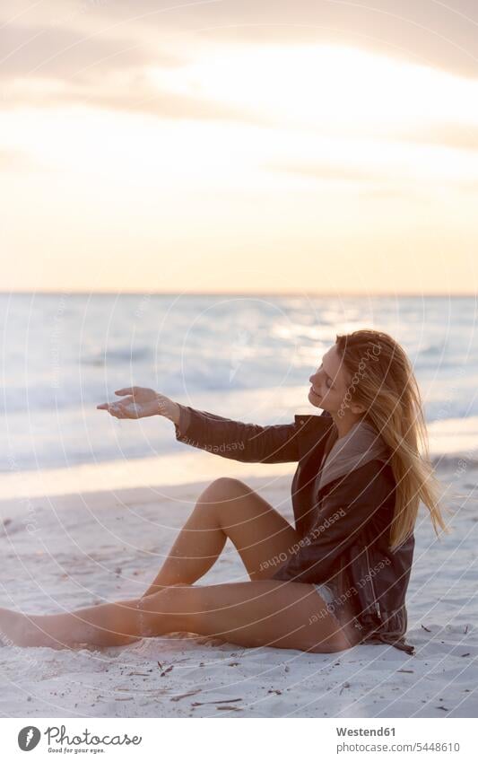Junge Frau genießt den Strand bei Sonnenuntergang Beach Straende Strände Beaches Auszeit Alles hinter sich lassen abschalten entspannen Meer Meere Urlaub Ferien