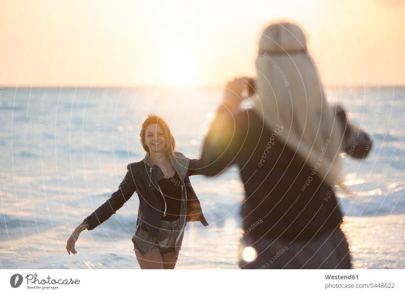 Freunde fotografieren am Strand bei Sonnenuntergang romantisch schwärmerisch schwaermerisch gefuehlvoll gefühlvoll Romantik Beach Straende Strände Beaches