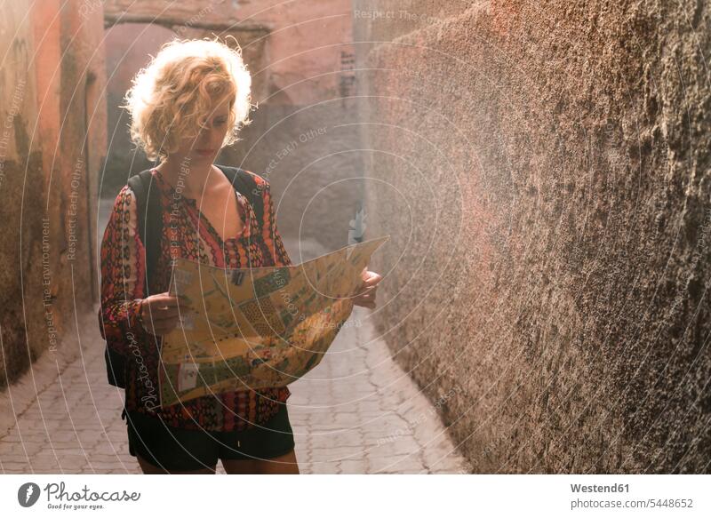 Marokko, Marrakesch, Tourist steht in einem Durchgang und schaut auf die Karte Gang Touristin Karten Frau weiblich Frauen stehen stehend Touristen Tourismus