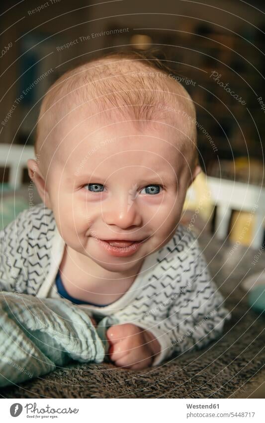 Glückliches drei Monate altes Baby, das aufschaut und etwas in seiner Wiege anlächelt lächeln Portrait Porträts Portraits Babies Babys Säuglinge Kind Kinder
