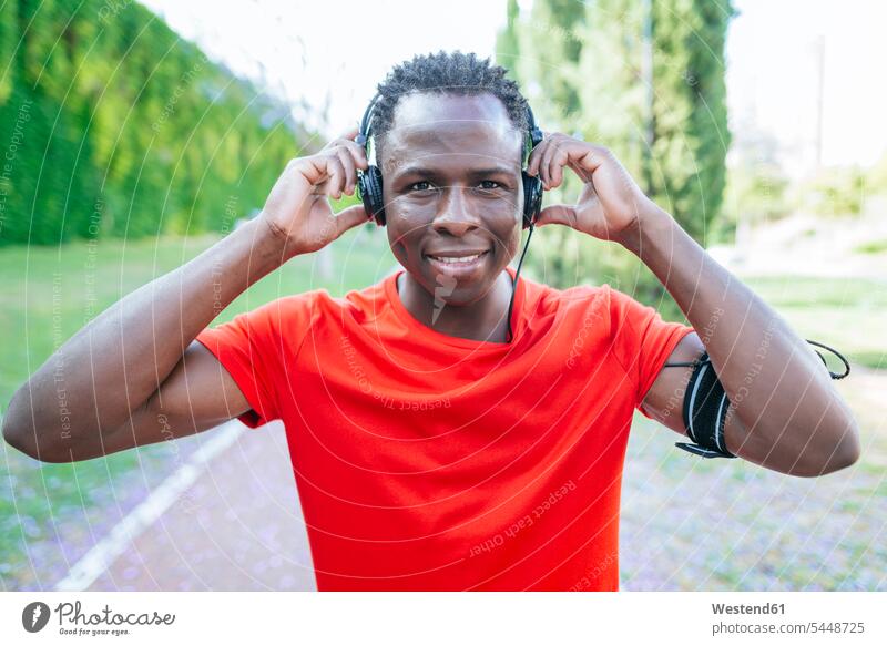 Porträt eines Mannes in Sportkleidung, der mit Kopfhörern Musik hört Männer männlich Kopfhoerer Portrait Porträts Portraits Erwachsener erwachsen Mensch