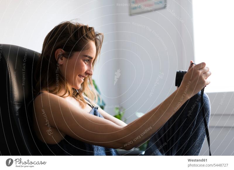 Lächelnde junge Frau schaut in die Kamera lächeln weiblich Frauen fotografieren Fotoapparat Fotokamera Selfie Selfies Erwachsener erwachsen Mensch Menschen