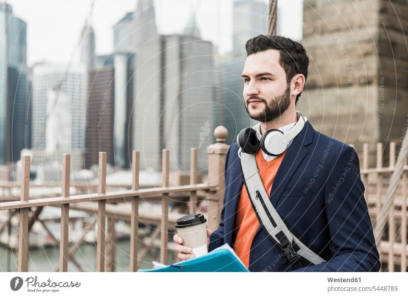 USA, New York City, Mann auf der Brooklyn Bridge mit Kaffee zum Mitnehmen New York State Männer männlich Brücke Bruecken Brücken Getränk Getraenk Getränke
