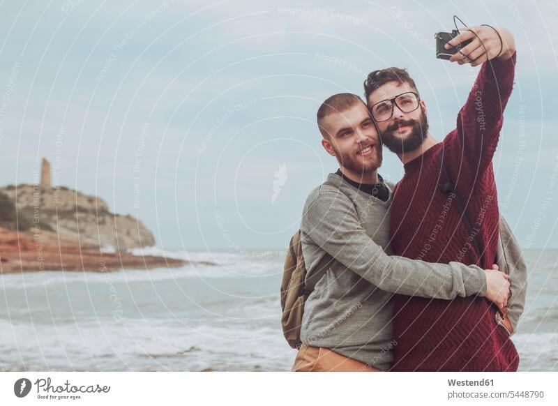 Spanien, Oropesa del Mar, schwules Paar macht Selfie vor dem Meer Selfies Pärchen Paare Partnerschaft Mensch Menschen Leute People Personen Meere Kamera Kameras