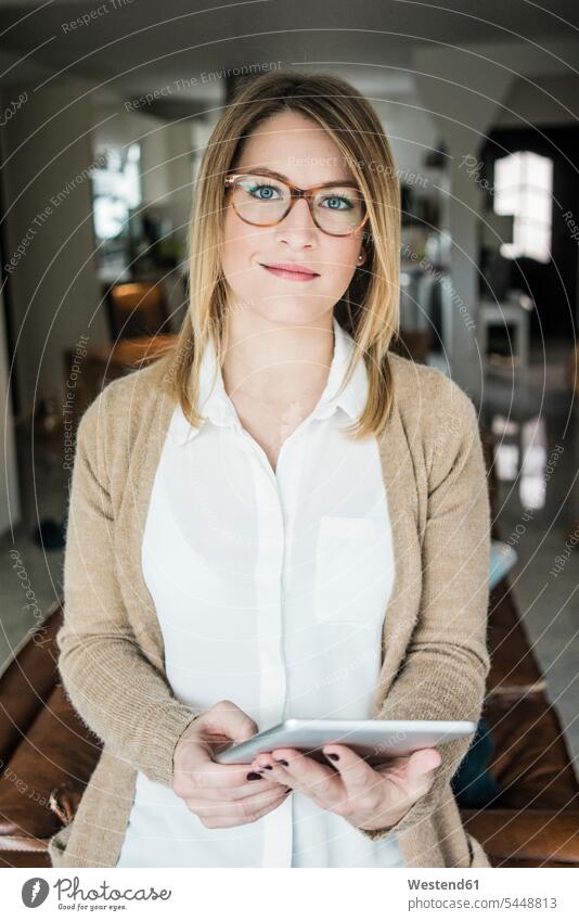 Porträt einer lächelnden Frau, die zu Hause eine Tablette hält Zuhause daheim Tablet Computer Tablet-PC Tablet PC iPad Tablet-Computer halten Portrait Porträts