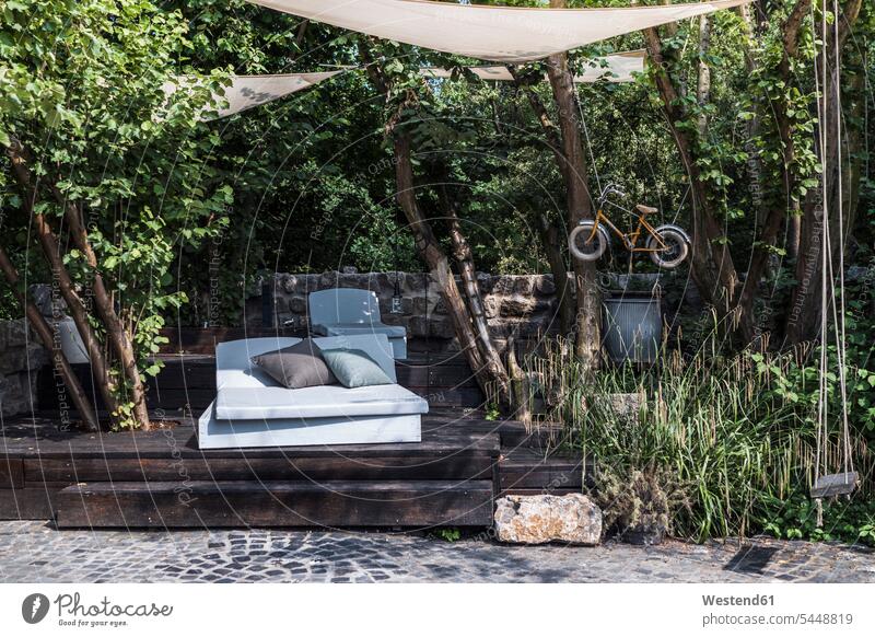 Deutschland, Sonnenbank im schattigen Teil eines üppigen Gartens Wohnen Gärten Gaerten üppig bewachsen saftig Außenaufnahme draußen im Freien Luxus Luxuriös