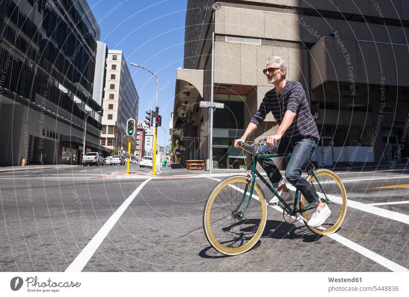Älterer Mann fährt Fahrrad in der Stadt Bikes Fahrräder Räder Rad radfahren fahrradfahren radeln unterwegs auf Achse in Bewegung staedtisch städtisch Männer
