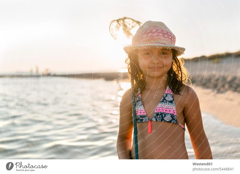 Spanien, Menorca, Porträt eines Mädchens mit einem Kescher am Strand weiblich spielen lächeln Beach Straende Strände Beaches Fanggerät Fanggeräte Kind Kinder
