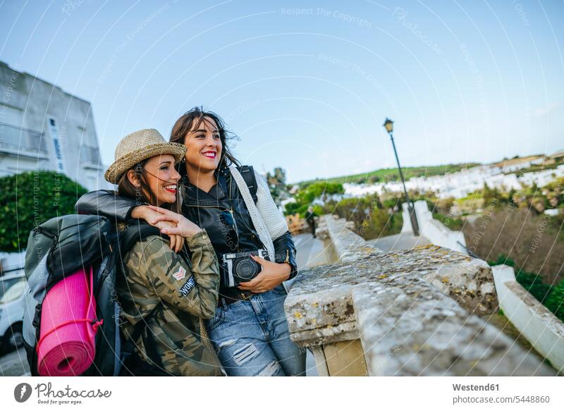 Zwei glückliche junge Frauen auf einer Reise Freundinnen Fotoapparat Kamera Fotokamera Freunde Freundschaft Kameradschaft Touristin weiblich Touristen Tourismus