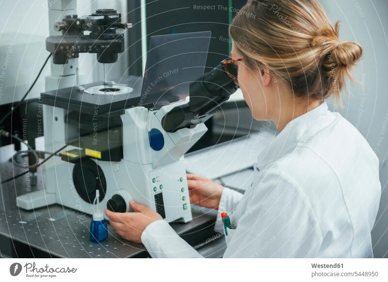 Labortechniker mit Mikroskop im Labor Frau weiblich Frauen untersuchen prüfen Labore Laborantin Laborantinnen arbeiten Arbeit Mikroskope Erwachsener erwachsen