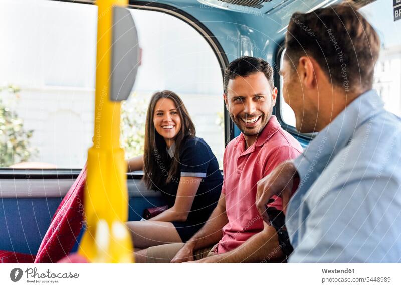 Großbritannien, London, drei Freunde sitzen in einem Doppeldeckerbus und unterhalten sich Portrait Porträts Portraits Bus Autobusse Busse Omnibus Omnibusse