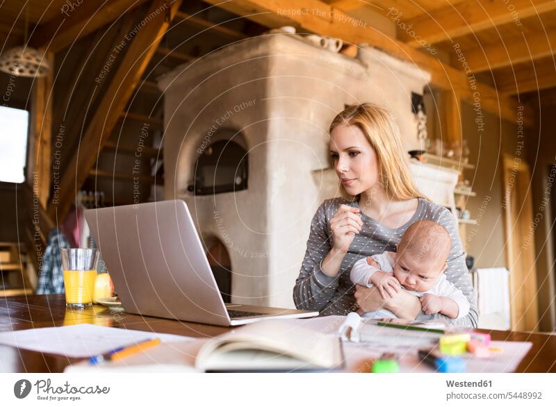 Mutter mit Baby zu Hause mit Laptop Babies Babys Säuglinge Kind Kinder Mami Mutti Mütter Mama Notebook Laptops Notebooks Mensch Menschen Leute People Personen