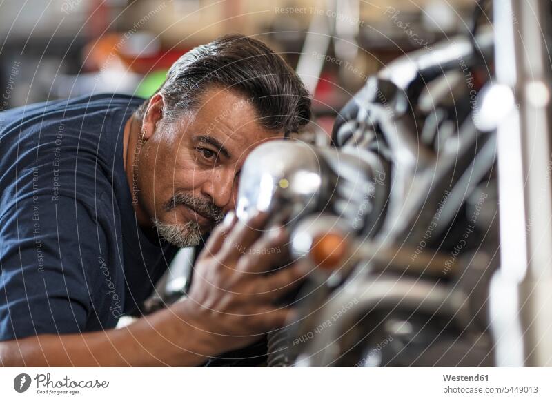 Mechaniker untersucht Motorrad in Werkstatt reparieren Reparatur arbeiten Arbeit Motorräder Monteur Kraftfahrzeug Verkehrsmittel KFZ Industrie industriell